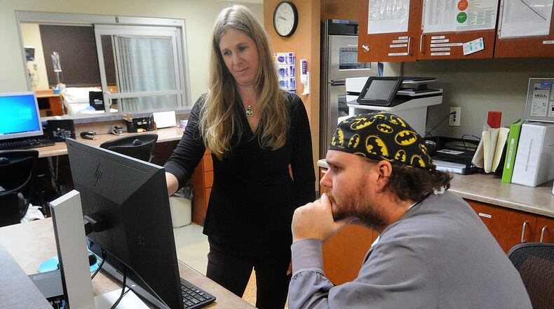 Carrie Carusone, Joint and Spine Program director at Greater Dayton Surgery Center, talks with Dr. Ross Brubaker at the
Greater Dayton Surgery Center. MARSHALL GORBY\STAFF