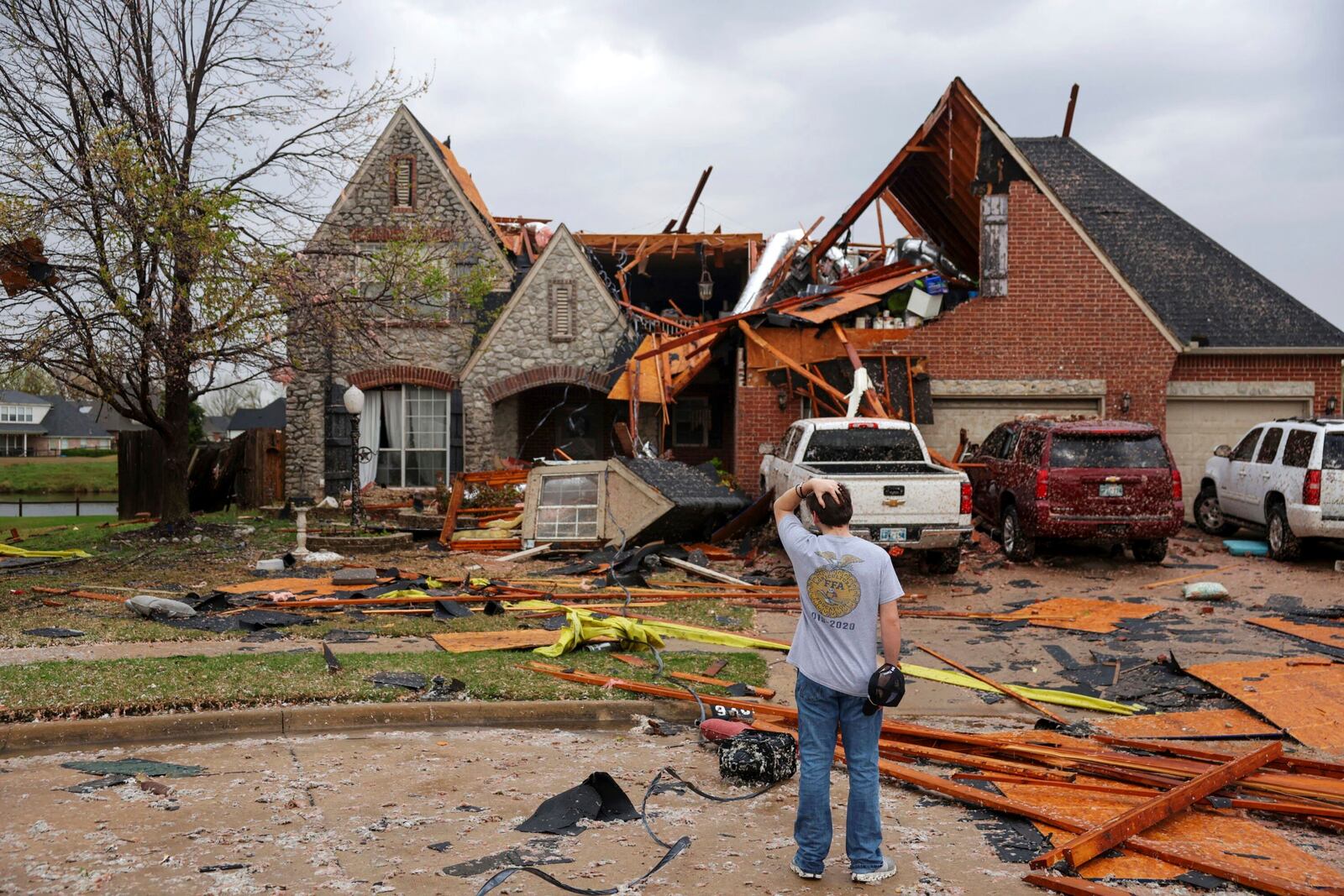 Ryland Mosley, 18, who was on the 2nd story of his home when the storm passed, stands outside of it observing the damage, Wednesday, April 2, 2025 in Owasso, Okla. (Mike Simons/Tulsa World via AP)