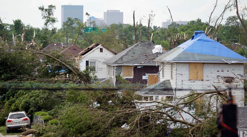 Tornado battered houses and trees along Rolfe Avenue in Harrison Twp. near Wagner Ford Road. TY GREENLEES / STAFF