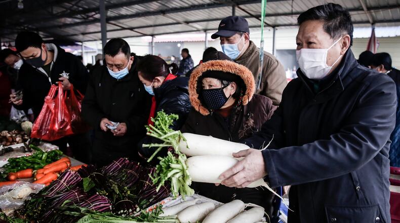 The resident wear masks to buy vegetables in the market on Wednesday in Wuhan, China. Flights, trains and public transport including buses, subway and ferry services have been temporarily closed and officials have asked residents told to stay in town in order to help stop the outbreak of a strain of coronavirus that has killed 17 people and infected over 500 in places as far away as the United States. This week marks the start of Chinese Lunar New Year holiday, the busiest season for Chinese travellers. (Getty Images/TNS)
