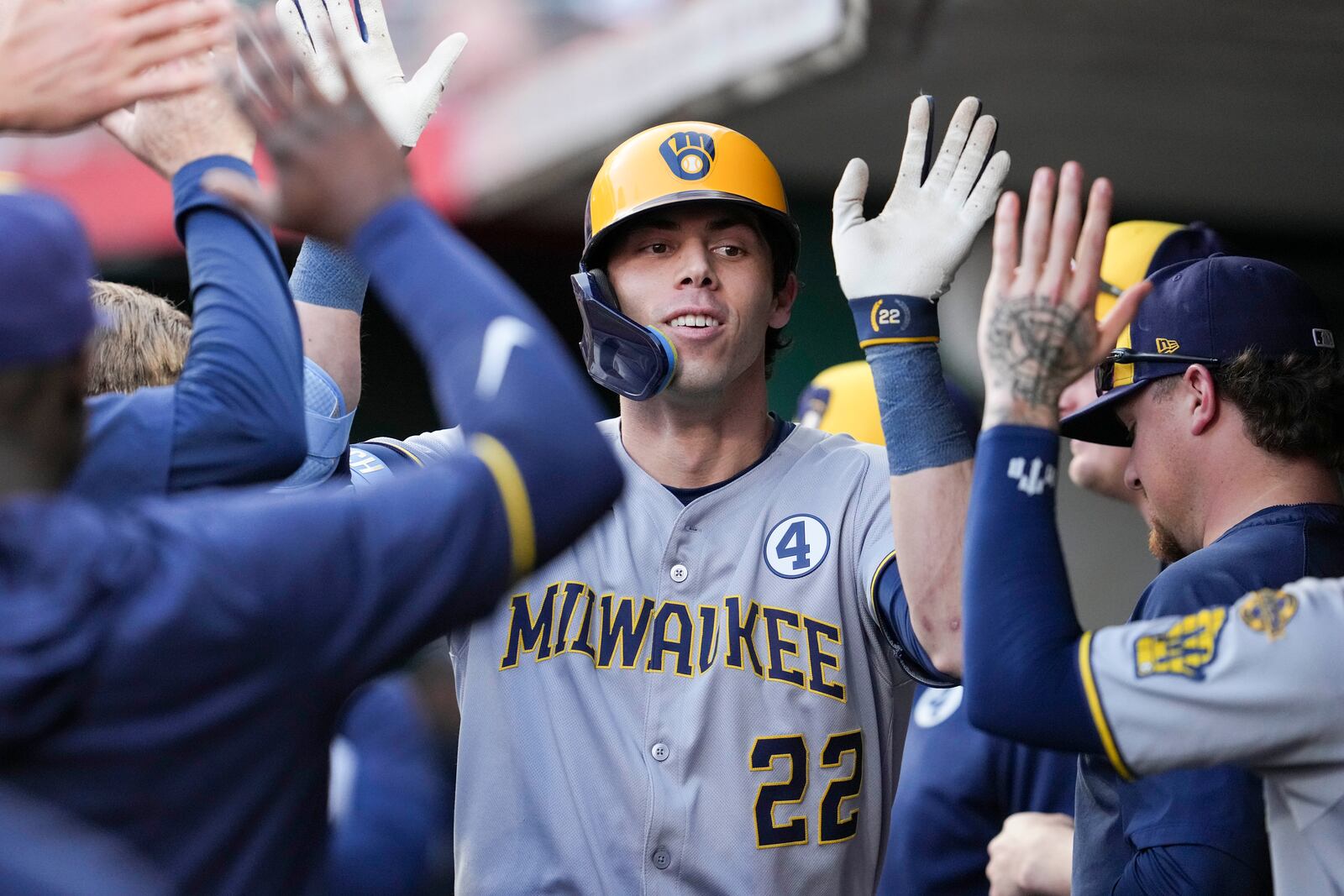 Milwaukee Brewers' Christian Yelich (22) celebrates with teammates after hitting a solo home run during the third inning of a baseball game against the Cincinnati Reds, Monday, June 2, 2025, in Cincinnati. (AP Photo/Jeff Dean)