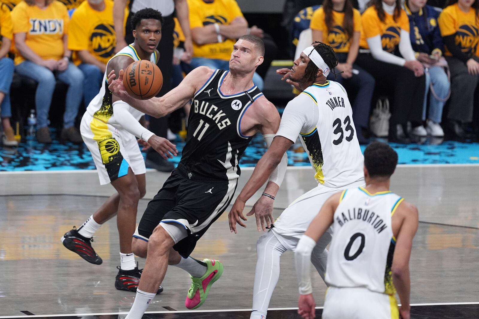Milwaukee Bucks' Brook Lopez (11) heads to the basket past Indiana Pacers' Myles Turner (33) during the first half of a first-round NBA basketball playoff game, Saturday, April 19, 2025, in Indianapolis. (AP Photo/Michael Conroy)