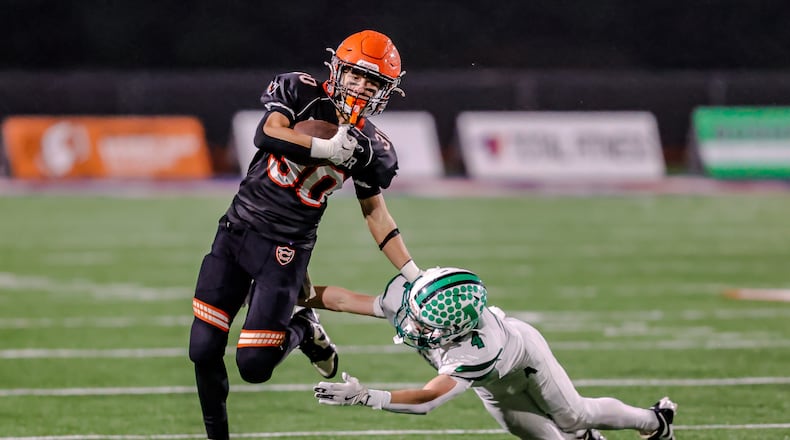 Coldwater High School sophomore John Pohlman runs past Anna's Zeb Pleiman during their game on Friday, Nov. 21, 2025, at Piqua's Alexander Stadium. The Cavaliers won 14-12 to win the Division VI, Region 24 final. MICHAEL COOPER / STAFF PHOTO