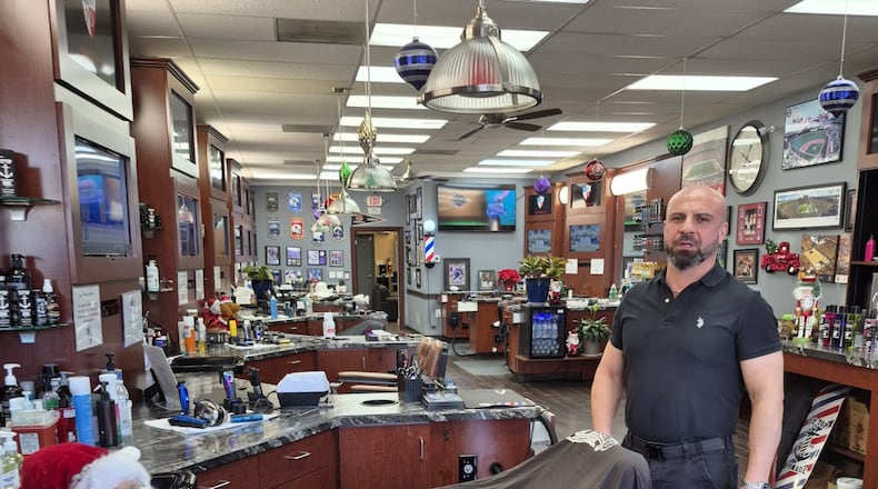 In 2005, Alex Dzhalilov came to the U.S. from Georgia with $154. In January, he will open his second barber shop to go along with the four houses he owns. MICHAEL KURTZ / STAFF