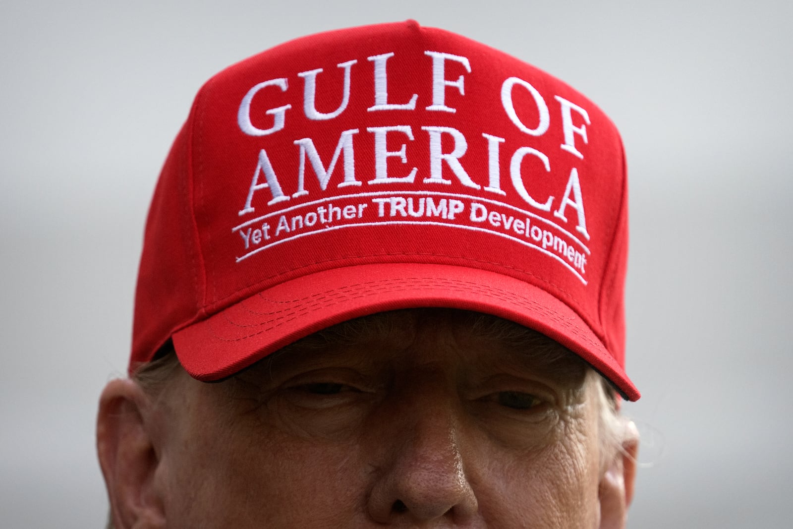 FILE - President Donald Trump wears a hat with the slogan "Gulf of America - Yet Another Trump Development" as he speaks to the media before walking across the South Lawn of the White House to board Marine One en route to Joint Base Andrews, Md., and on to Florida, July 1, 2025, in Washington. (AP Photo/Mark Schiefelbein, File)