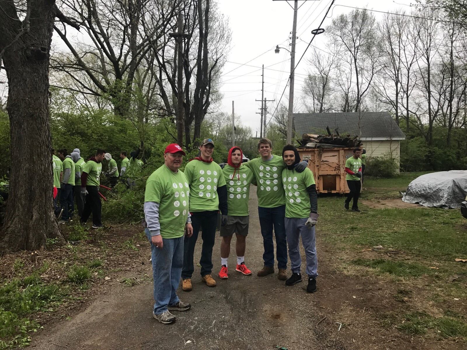 UD foorball coach Rick Chamberlin (left) and some of his players stand together in an alley between Hopeland St. and Cincinnati Street that they cleaned up Saturday. Tom Archdeacon/STAFF