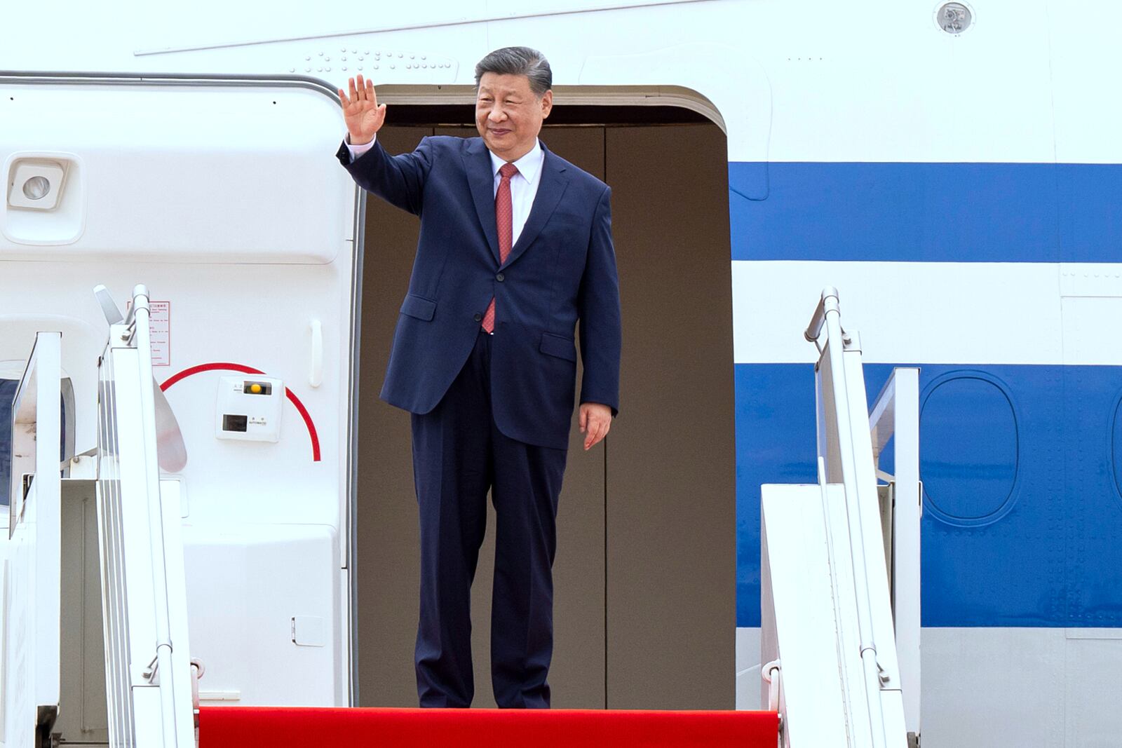 In this photo released by Agence Kampuchea Press (AKP), Chinese President Xi Jingping waves from a plane during a send-off ceremony at Phnom Penh International Airport in Phnom Penh, Cambodia, Friday, April 18, 2025. (AKP via AP)