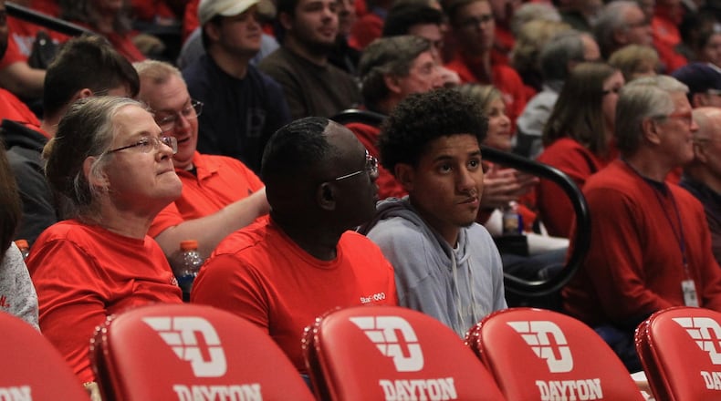 Zimife Nwokeji, right, sits behind the Dayton bench on Saturday, Dec. 14, 2019, at UD Arena.