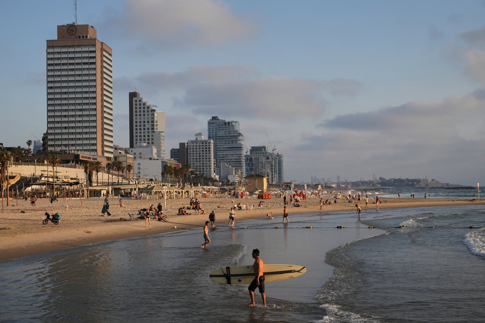 People spend the day on the Mediterranean Sea beachfront in Tel Aviv, Israel, on Saturday, June 14, 2025. (AP Photo/Ohad Zwigenberg)