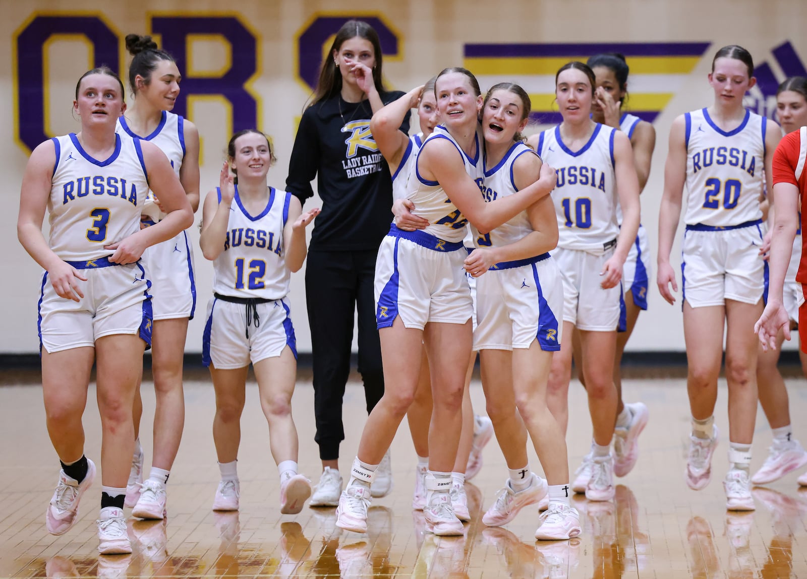 Russia junior forward Celeste Borchers (center left) celebrates with senior guard Callie Goubeaux (center right) after Russia beat Cedarville 40-32 in a Division VII regional final on Saturday, March 7 at Vandalia-Butler's Student Activity Center. BRYANT BILLING / STAFF