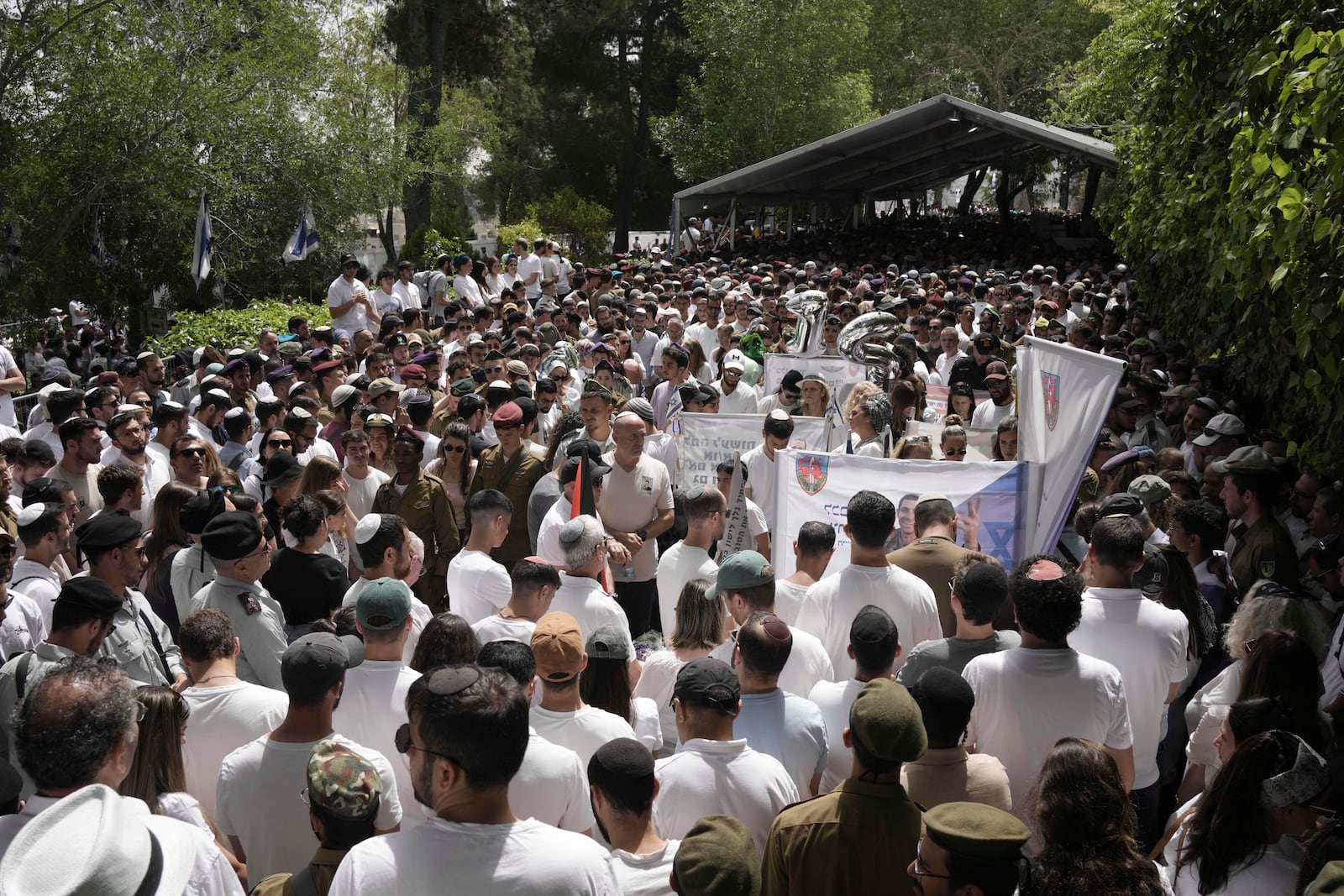 People and Israeli soldiers stand during two minutes of silence as air raid sirens sound marking the Israel's annual Memorial Day for the fallen soldiers and victims of nationalistic attacks at Mount Herzl military cemetery in Jerusalem, Wednesday, April 30, 2025. (AP Photo/Maya Alleruzzo)