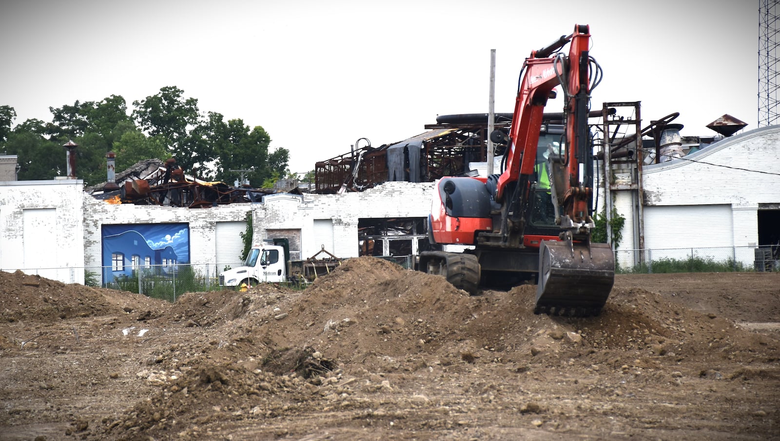 Construction crews work on a site near the Wright Co. airplane factory buildings in West Dayton that caught fire in March 2023. Officials with the National Aviation Heritage Area and the Dayton Aviation Heritage National Historical Park say the top part of the facade of building 1 has partially collapsed. They believe this likely happened in July 2025. CORNELIUS FROLIK / STAFF