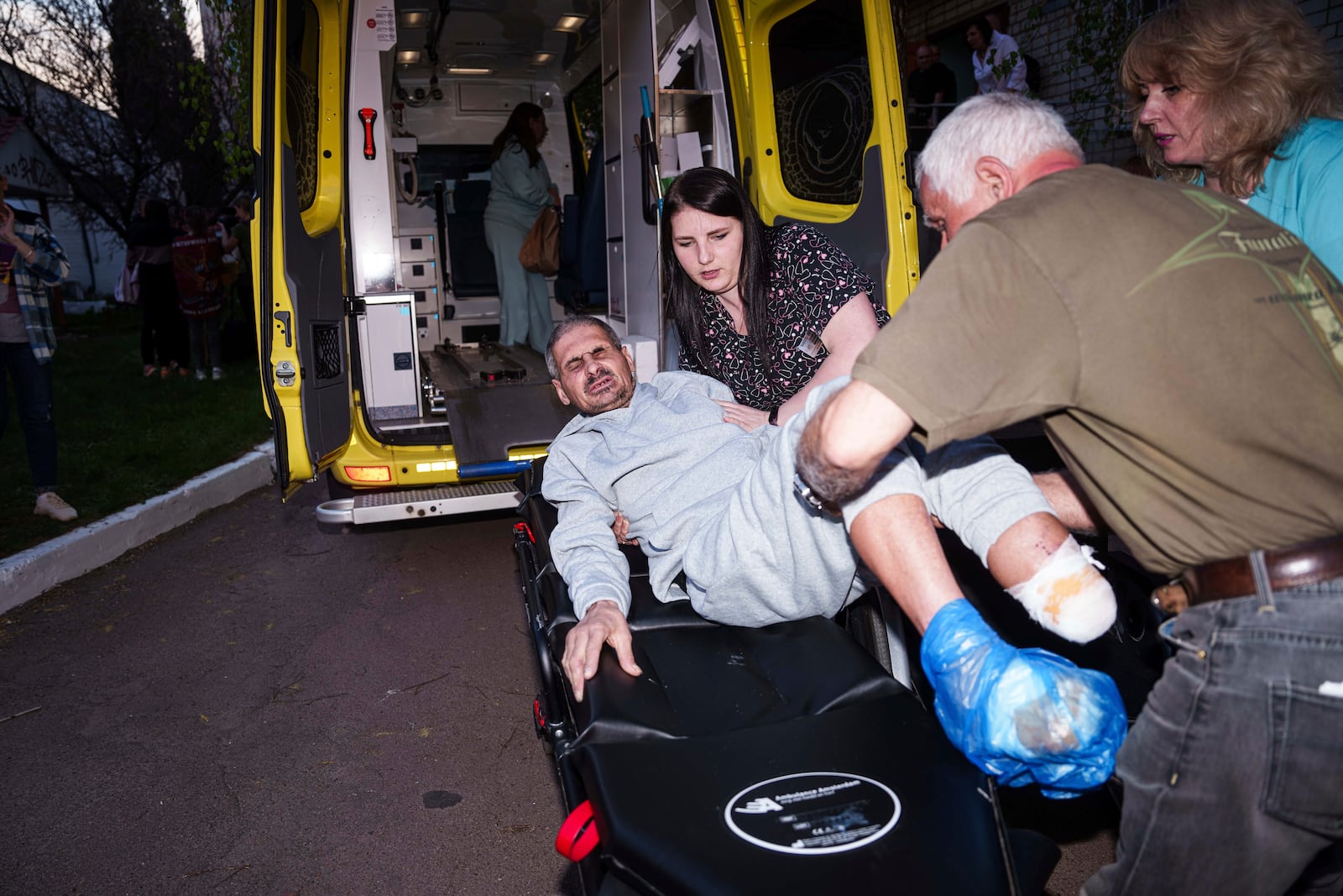 An injured Ukrainian soldier who was a prisoner of war is placed on a stretcher after being returned to his home country by Russia, April. 19, 2025. (AP Photo/Evgeniy Maloletka)