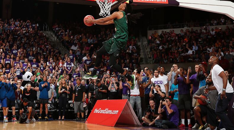 Wright State’s Steven Davis throws down his first attempt, which featured him approaching the rim from behind the baseline after taking a pass off the backboard from assistant coach Sharif Chambliss (lower right), during the NCAA Slam Dunk Contest on Thursday night in Phoenix. Steve Woltmann/Contributed photo