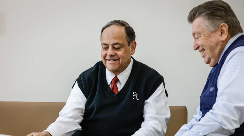 Rafi Rodriguez, left, president of Rodriguez Financial Strategies LLC in Beavercreek meets with his client, Randy Gallas, for regular retirement  checkups. JIM NOELKER/STAFF