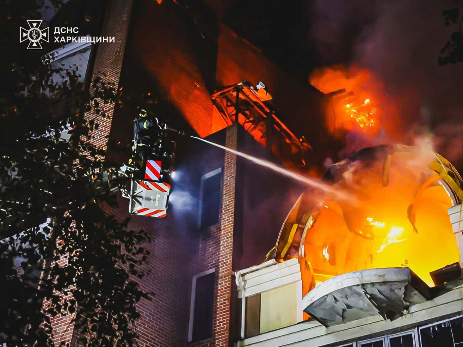 In this photo provided by the Ukrainian Emergency Service, firefighters put out a fire following Russia's massive air attack in Kharkiv, Ukraine, Friday, June 20, 2025. (Ukrainian Emergency Service via AP)