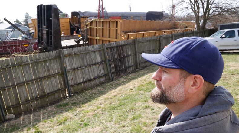 Lane Martin, the owner of Ability Builders, watches the cleanup of the train derailment on the other side of his fence Monday, March 6, 2023. Lane said he feels lucky that Saturday’s derailment stopped just before his Springfield Twp. business. BILL LACKEY/STAFF