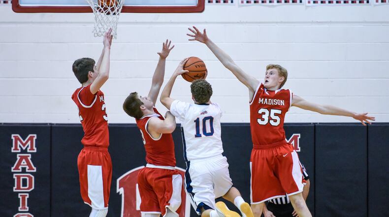 Miami Valley’s Alec Martin takes a shot while being defended by Madison’s Grant Whisman (32), Mason Whiteman (3) and Kevin Duritsch (35) during their game in the Brian Cook Classic on Thursday night at Madison. NICK GRAHAM/STAFF