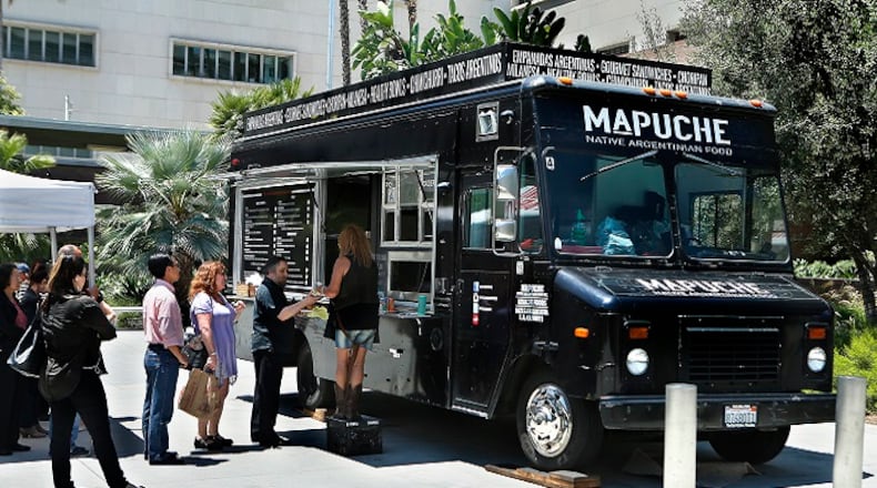 Customers wait in line at Mapuche, an Argentinian food truck, parked at Grand Park in downtown Los Angeles on July 26, 2017. (Mel Melcon/Los Angeles Times/TNS)