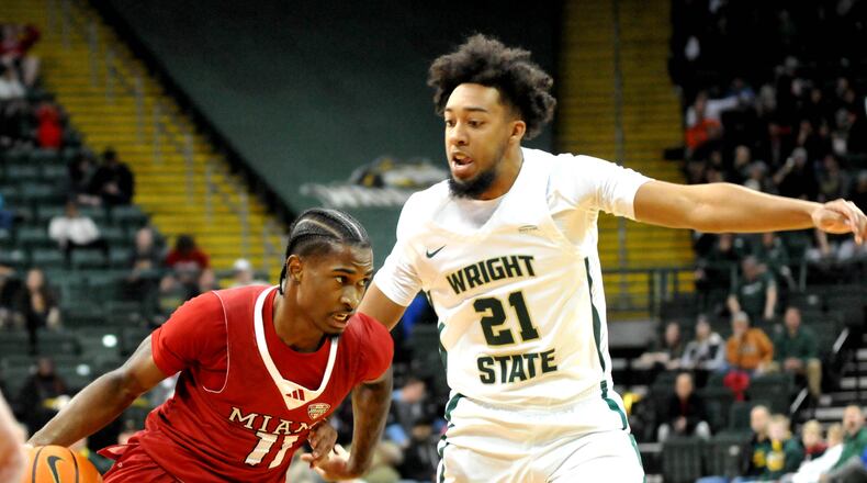 Miami's Mekhi Cooper, 11, drives past Wright State's Logan Woods, 21, during a nonconference game at Wright State's Nutter Center on Tuesday, Dec. 19, 2023. DAVID A. MOODIE/CONTRIBUTING PHOTOGRAPHER