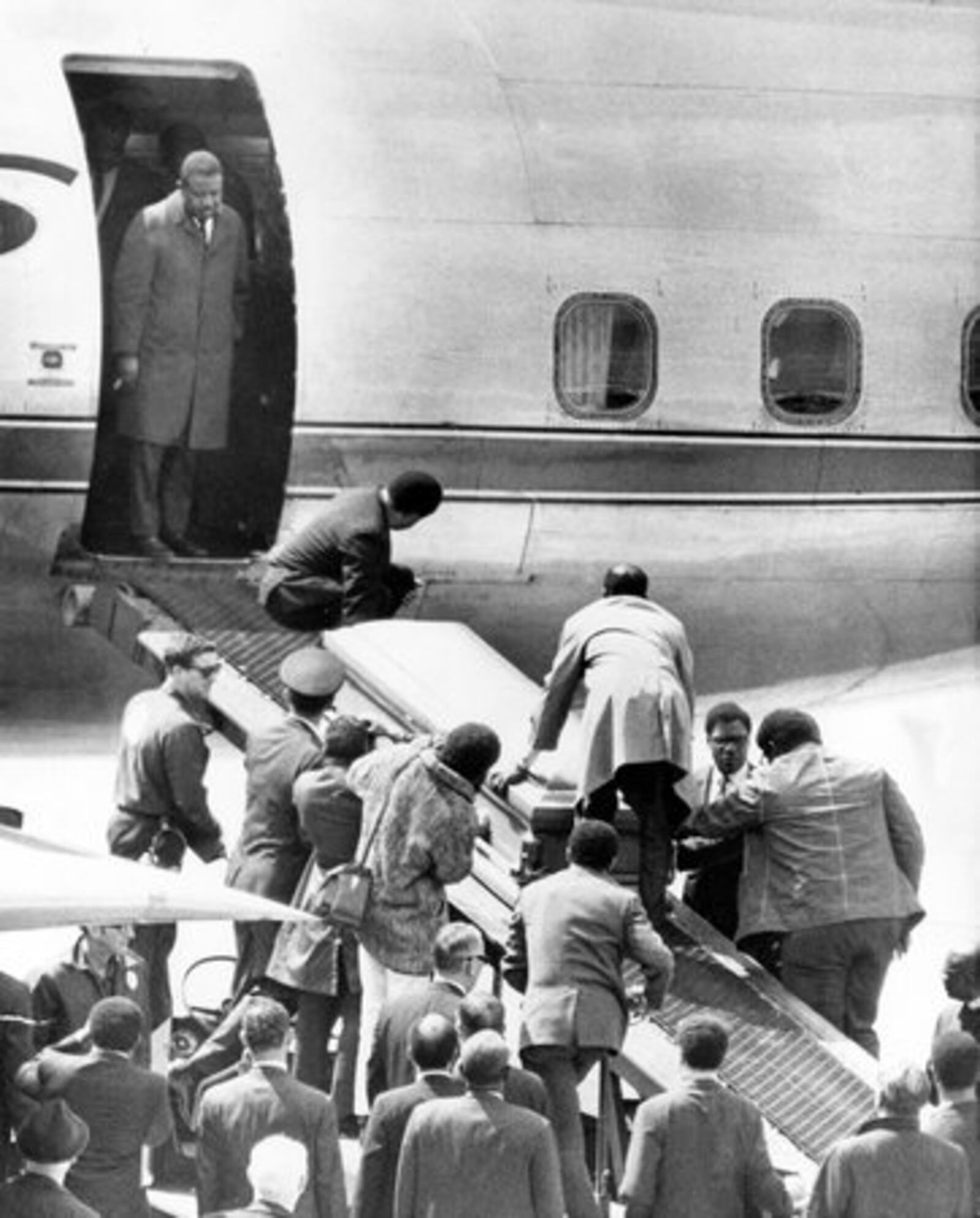 The casket bearing the body of slain civil rights leader Dr. Martin Luther King Jr., is taken up a loading ramp and placed aboard an airliner to his hometown Atlanta, Ga., on April 5, 1968, at the airport of Memphis, Tennessee. The Rev. Ralph Abernathy, King's closest associate and named to replace Dr. King as head of the SCLC, stands in the doorway of the plane.