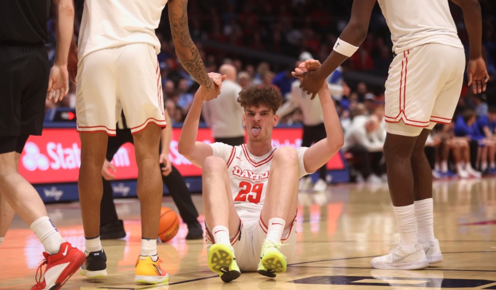 Dayton's Amaël L'Etang gets help from teammates after drawing a foul in the second half against Saint Louis on Tuesday, Feb. 24, 2026, at UD Arena. David Jablonski/Staff