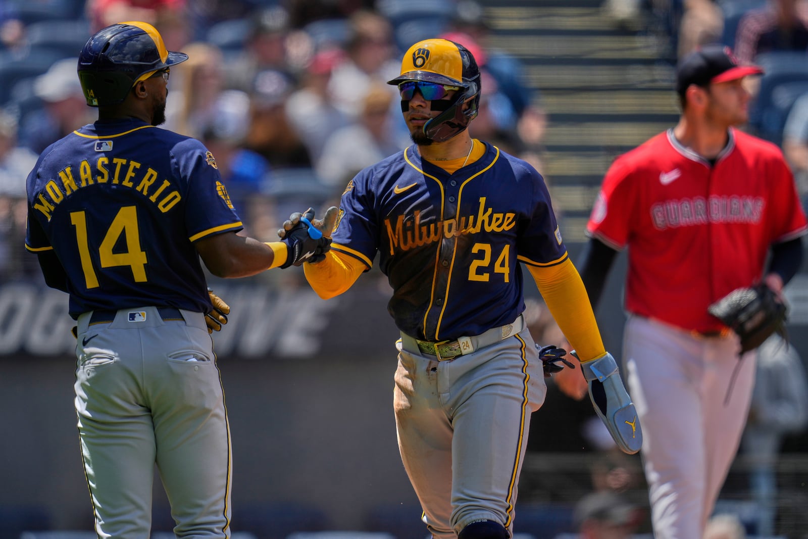 Milwaukee Brewers' William Contreras (24) is congratulated by teammate Andruw Monasterio (14) after scoring in the second inning of a baseball game against the Cleveland Guardians in Cleveland, Wednesday, May 14, 2025. (AP Photo/Sue Ogrocki)