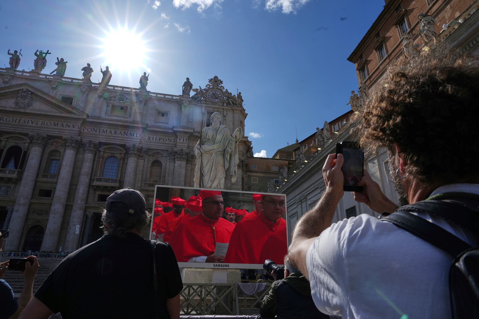 Faithful watch a giant screen showing images of cardinals entering the conclave, in St. Peter's Square at the Vatican, Wednesday, May 7, 2025. (AP Photo/Andrew Medichini)