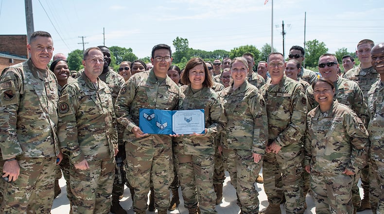 Chief Master Sergeant of the Air Force JoAnne Bass and other Airmen from Wright-Patterson Air Force Base pose for a photo with Airman 1st Class Leonardo Castillo Coronado, a medical technician with the 88th Medical Group, after he found out he had been selected for promotion to senior Airman during a ‘Total Force Barbecue’ on June 4. U.S. AIR FORCE PHOTO/WESLEY FARNSWORTH
