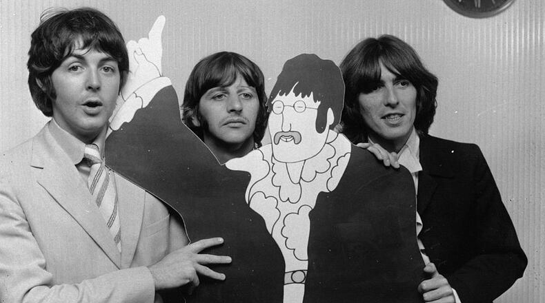 FILE PHOTO: Beatles Paul McCartney, Ringo Starr and George Harrison (1943 - 2001) pose with a cartoon cut-out of fellow Beatle John Lennon (1940 - 1980), at a press review of the group's animated film 'Yellow Submarine'. Starr will host a sing-a-long on YouTube.