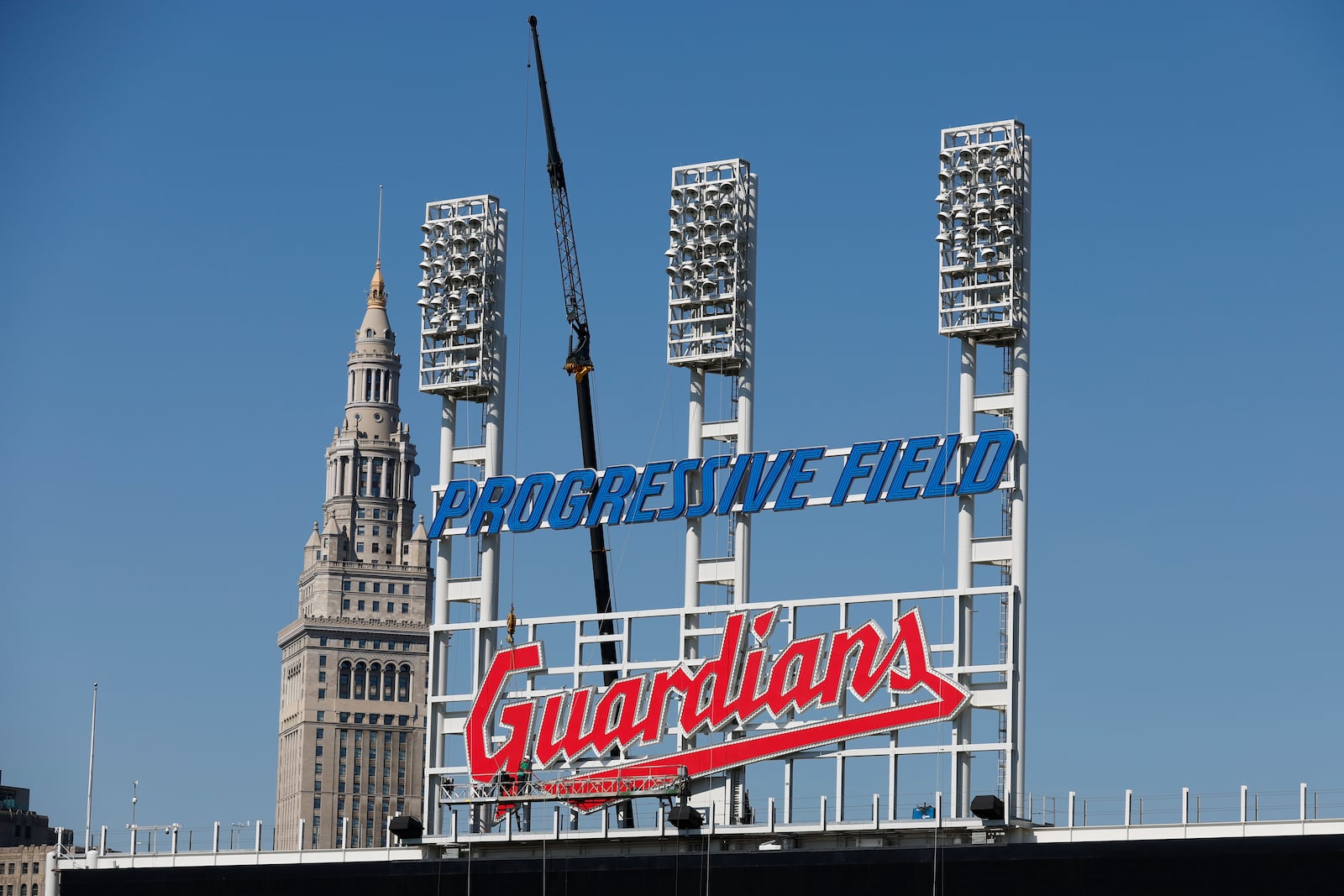 FILE - Workers finish installing the Cleveland Guardians sign above the scoreboard at Progressive Field, March 17, 2022, in Cleveland. (AP Photo/Ron Schwane, file)