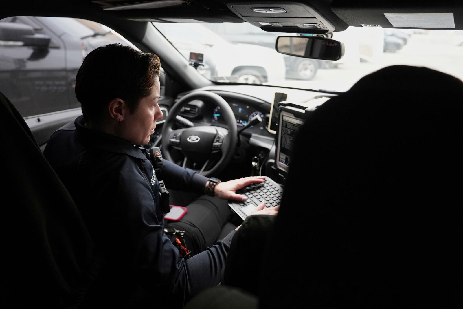Crisis Intervention Response Team (CIRT) members Philadelphia Police Officer Vanity Cordero, left, and Therapist Krystian Gardner check a computer for calls to assist on in Philadelphia, Friday, March 14, 2025. (AP Photo/Matt Rourke)