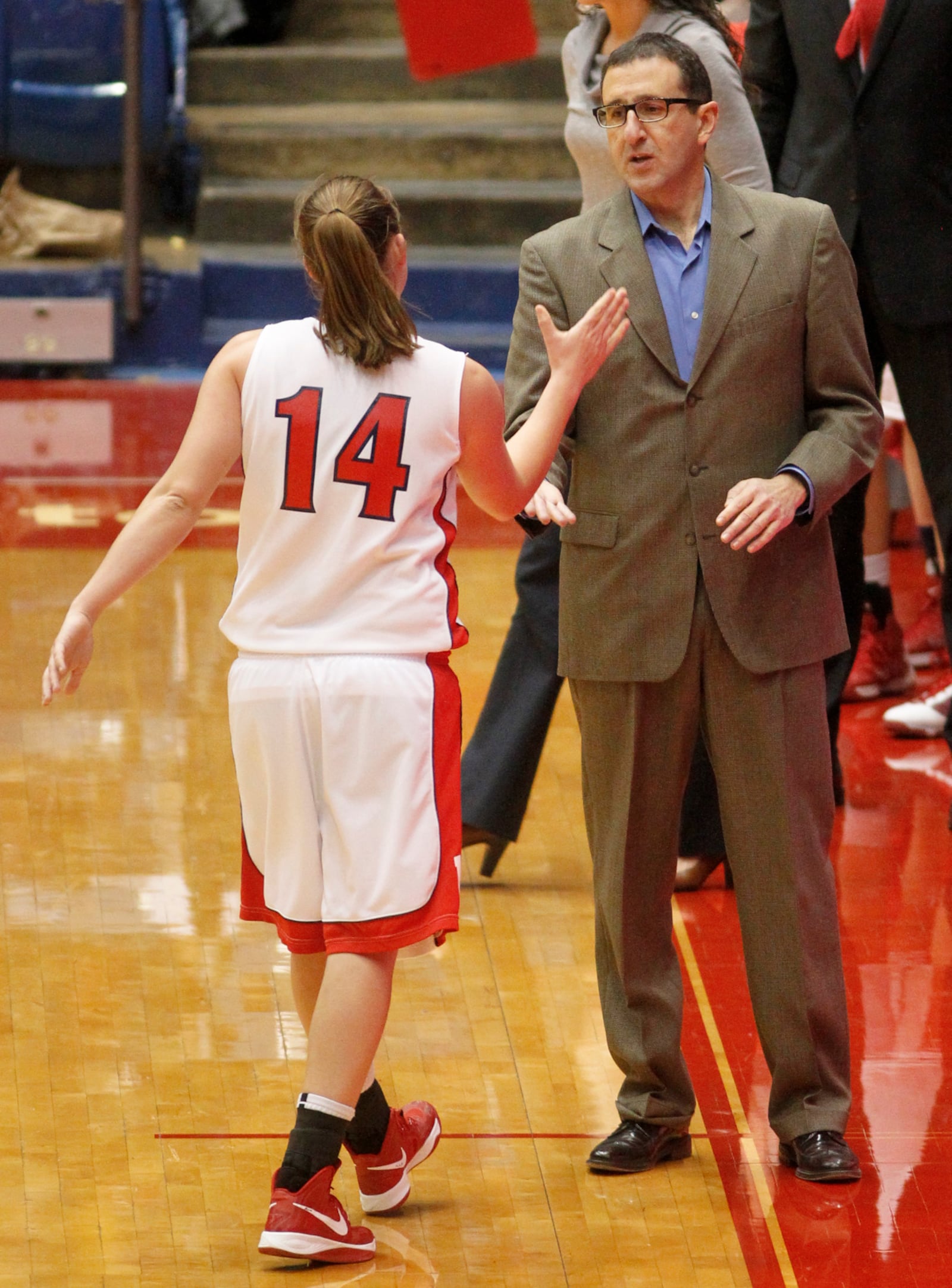 University of Dayton head coach Jim Jabir greets Sam MacKay as she leaves the floor Thursday at UD Arena. UD beat George Washington 80-52. STAFF PHOTO BY LISA POWELL