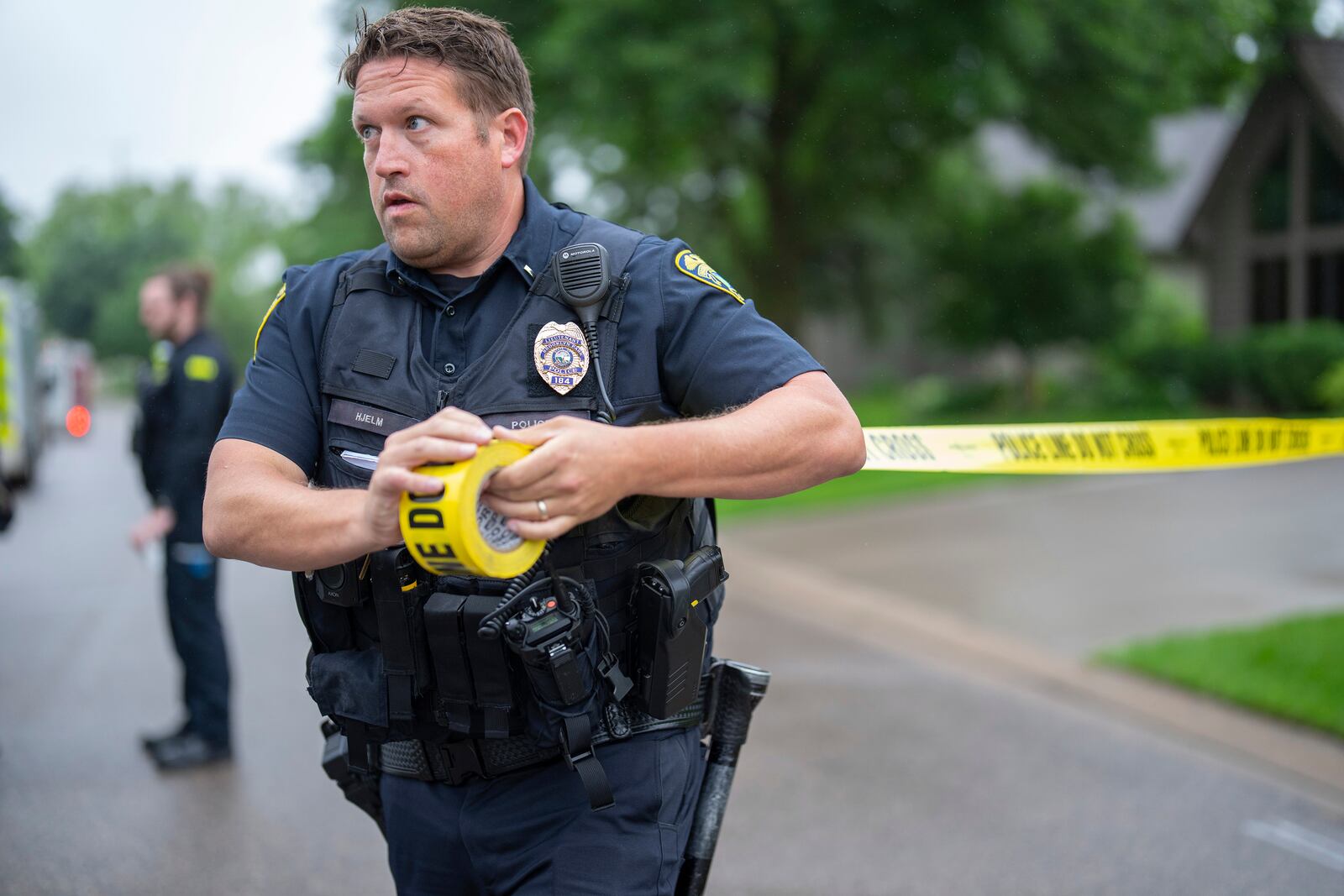 Brooklyn Park Police Lieutenant Hjelm sets up a perimeter with police tape near the scene of a shooting in Brooklyn Park, Minn. on Saturday, June 14, 2025. (Alex Kormann/Star Tribune via AP)