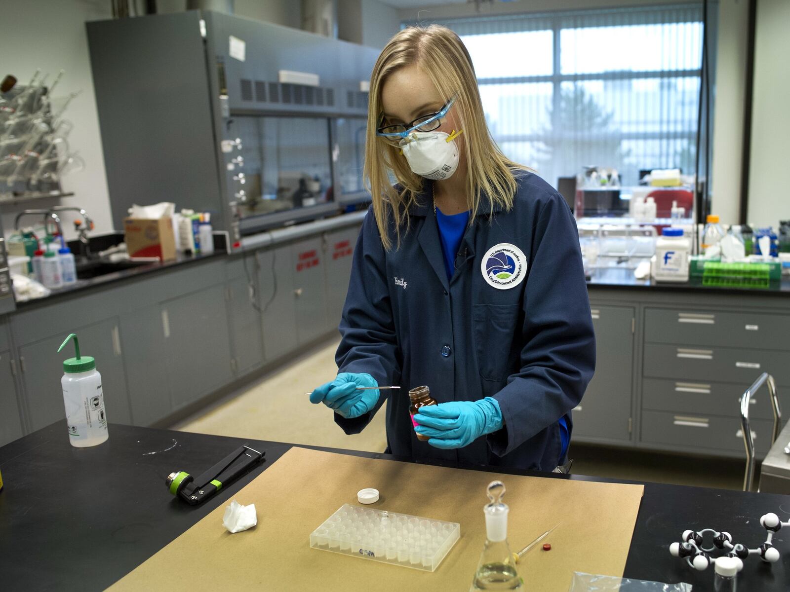 In this Tuesday, Aug. 9, 2016 photo, Drug Enforcement Administration (DEA) Forensic Chemist Emily Dye, prepares a control reference sample of fentanyl at the DEA’s Special Testing and Research Laboratory in Sterling, Va. A novel class of deadly drugs is exploding across the country, with many manufactured in China for export around the world. The drugs, synthetic opioids, are fueling the deadliest addiction crisis the U.S. has ever seen. (AP Photo/Cliff Owen)