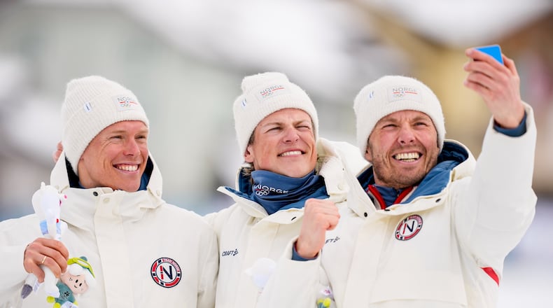 Silver medalist Martin Loewstroem Nyenget, gold medalist Johannes Hoesflot Klaebo and bronze medalist Emil Iversen, all three of Norway, pose on the podium of the cross country skiing men's 50km mass start Classic at the 2026 Winter Olympics, in Tesero, Italy, Saturday, Feb. 21, 2026. (AP Photo/Matthias Schrader)