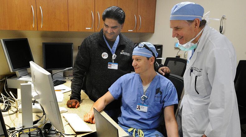 From left, Kettering Health cardiologists Dr. Niranjan Reddy, chief of interventional cardiology at Kettering Health; Dr. Ammar Safar, chief of cardiology at Kettering Health Main Campus; and Dr. Brian Schwartz, director for the heart and vascular service line at Kettering Health, use predictive software from Terumo, which utilizes patient data to determine their risks and reduce unwanted outcomes, to improve their processes in cardiology. MARSHALL GORBY\STAFF