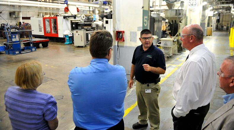 Dan Szklany, plant manager at Orbis in Urbana, leads a tour of the plant for a group from Ohio-Hi Point and Triad in April 2017. Bill Lackey/Staff