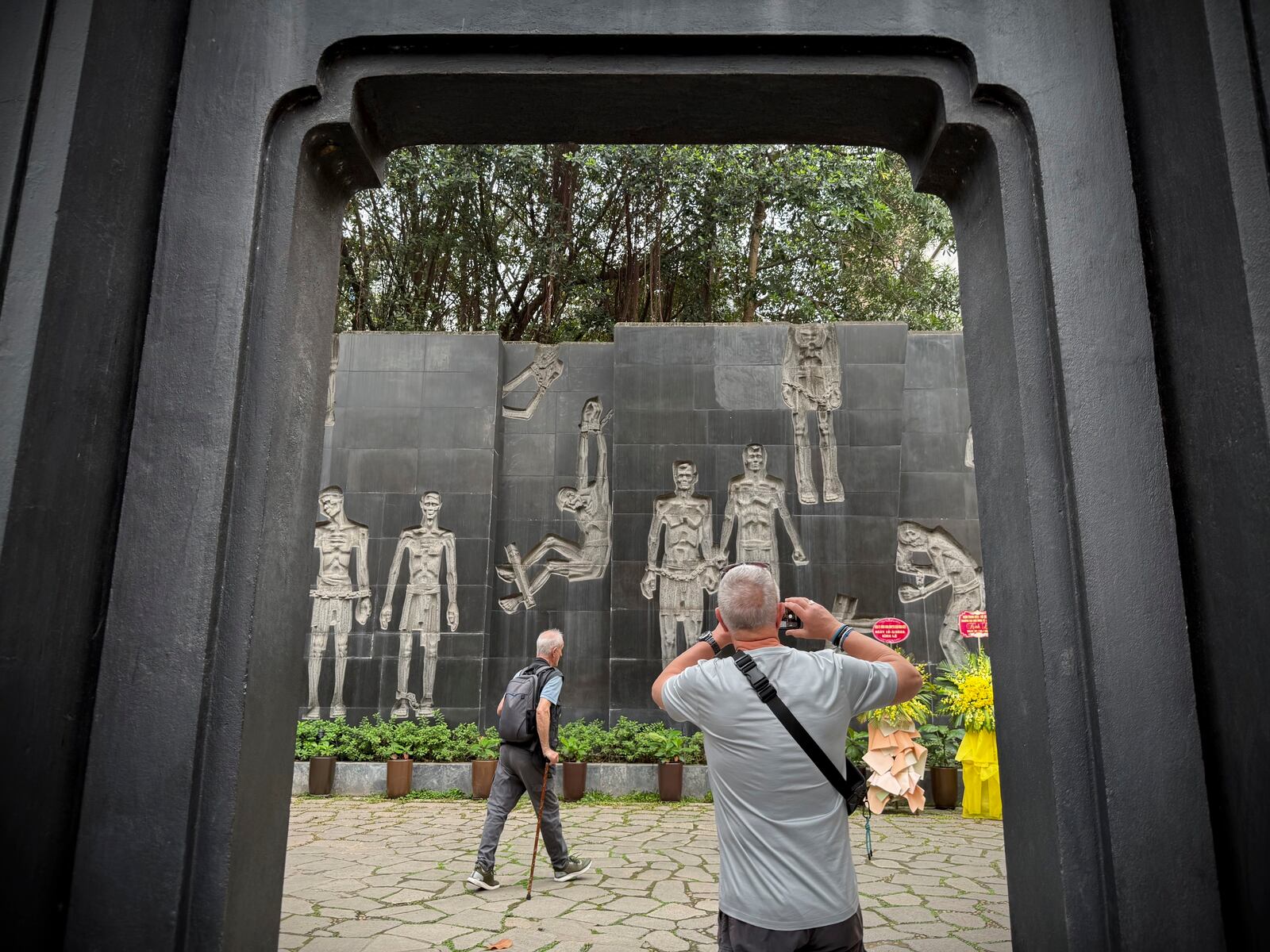 A tourist takes photos of a mural at the Hoa Lo prison museum in Hanoi, Vietnam, March 26, 2025. (AP Photo/Hau Dinh)