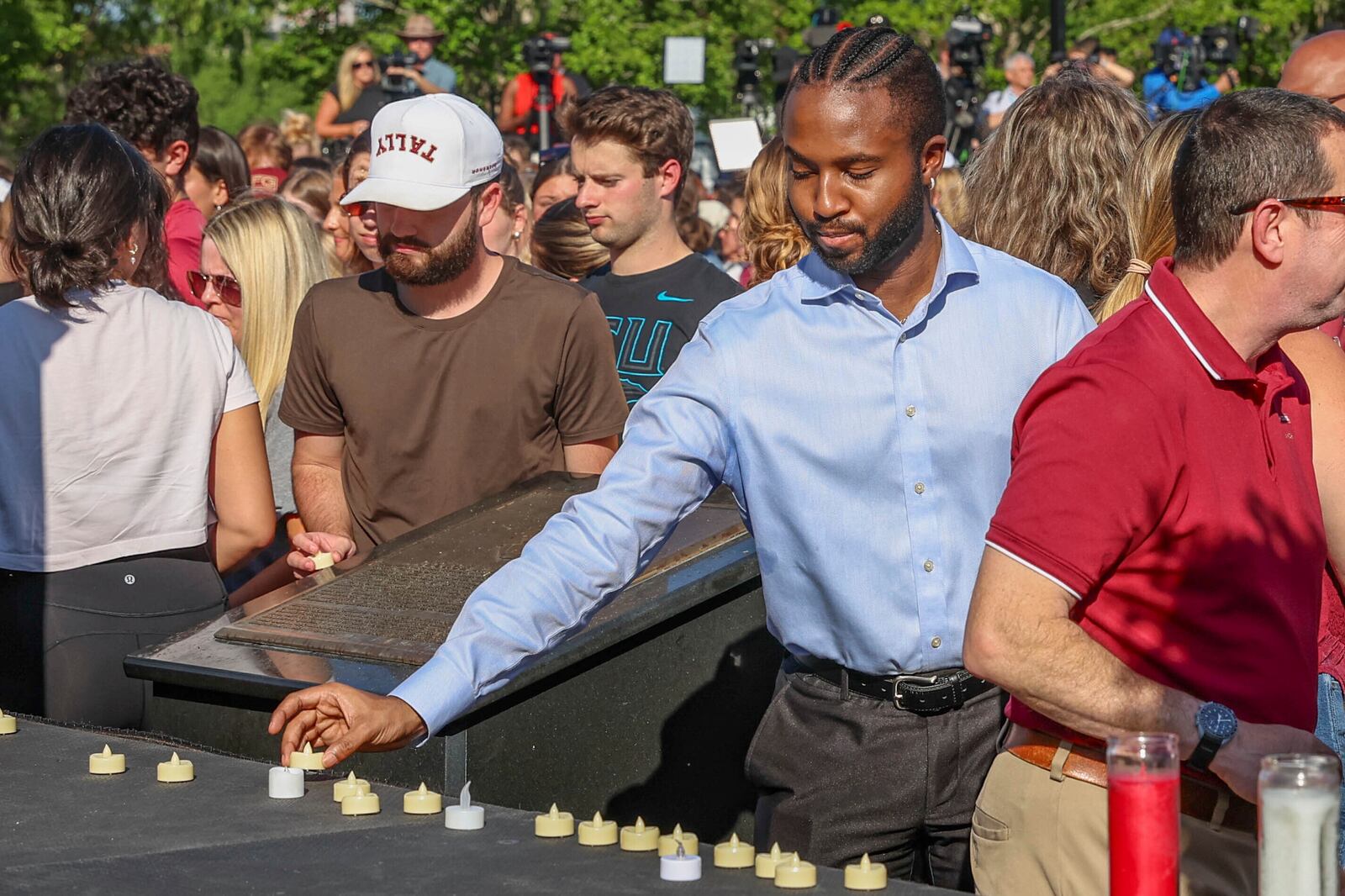 The day after an active shooter on campus Florida State students place electronic candles on a platform during a vigil on campus at Langford Green, Tallahassee, Fla., Friday, April 18, 2025. (AP Photo/Gary McCullough)