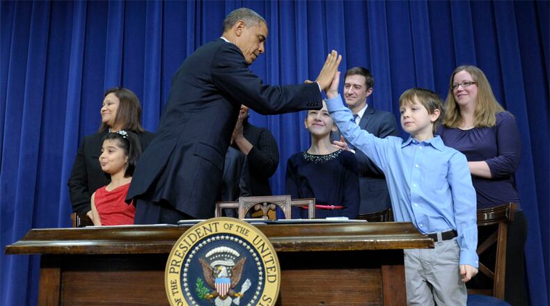 President Barack Obama gets a high-five from 8-year-old letter writer Grant Fritz during a news conference on proposals to reduce gun violence, Wednesday, Jan. 16, 2013, in the South Court Auditorium at the White House in Washington. Obama and Biden were joined by law enforcement officials, lawmakers and children who wrote the president about gun violence following the shooting at an elementary school in Newtown, Conn., last month.