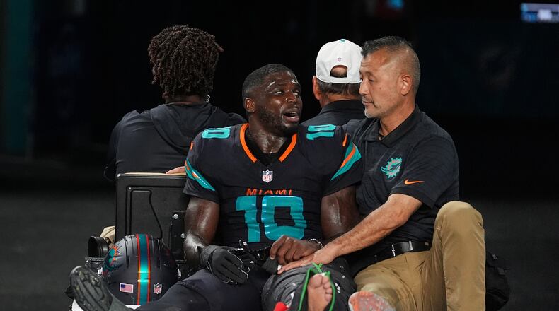 Miami Dolphins wide receiver Tyreek Hill (10) talks with a staff member as he is carted off the field after suffering an unknown lower leg injury in the second half of an NFL football game against the New York Jets, Monday, Sept. 29, 2025, in Miami Gardens, Fla. (AP Photo/Rebecca Blackwell)