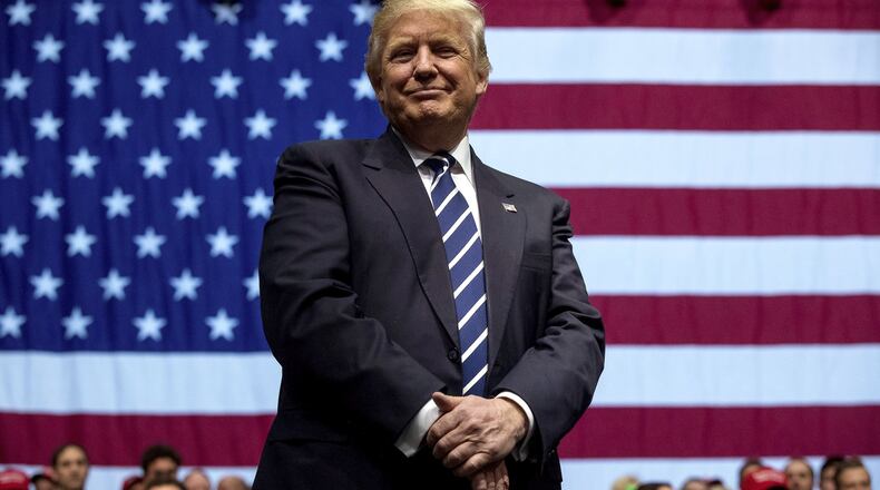 In this Dec. 9, 2016, photo, President-elect Donald Trump smiles during a rally at DeltaPlex Arena in Grand Rapids, Mich. Trump dismissed reports Monday that Russians attempted to intervene in the U.S. elections. (AP Photo/Andrew Harnik)