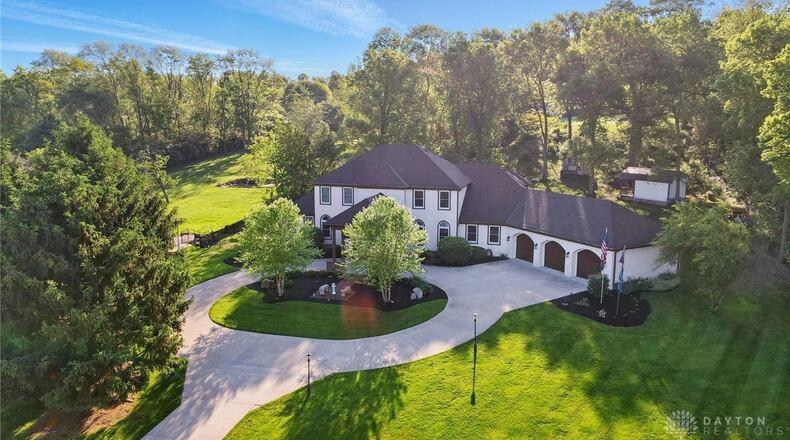 The front of this estate style home has a circular driveway, covered front entry and three car attached garage.