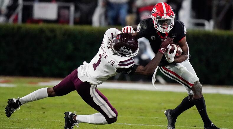 FILE -Mississippi State cornerback Martin Emerson, left, tackles Georgia wide receiver George Pickens during the first half of an NCAA college football game Saturday, Nov. 21, 2020, in Athens, Ga. Georgia wide receiver George Pickens still has a chance to be a major contributor for the Bulldogs this season. The junior who was expected to be third-ranked Georgia's go-to receiver before he tore the ACL in his right knee during spring practice will be available Friday, Dec. 31, 2021 for the College Football Playoff semifinal at the Orange Bowl against No. 2 Michigan. (AP Photo/Brynn Anderson, File)