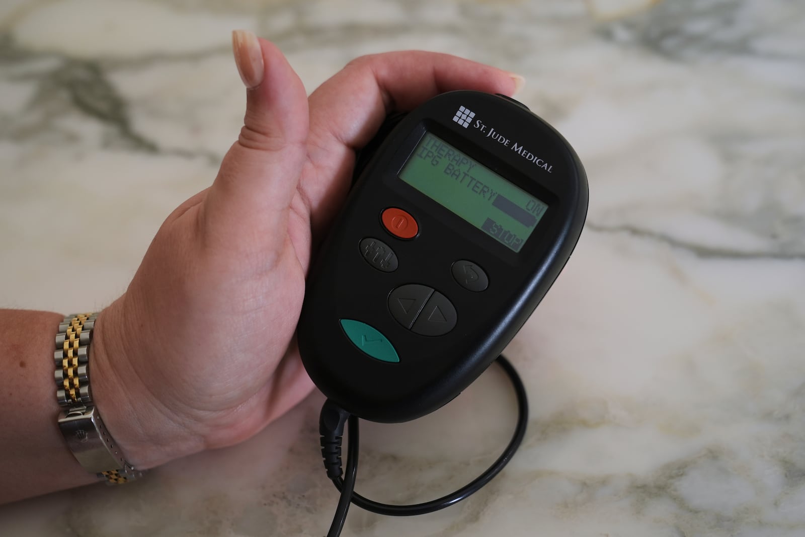 Brandy Ellis checks the battery levels of a pacemaker-like device that was installed in her chest as part of an experimental treatment for depression, on Thursday, July 24, 2025, in Delray Beach, Fla. (AP Photo/Marta Lavandier)