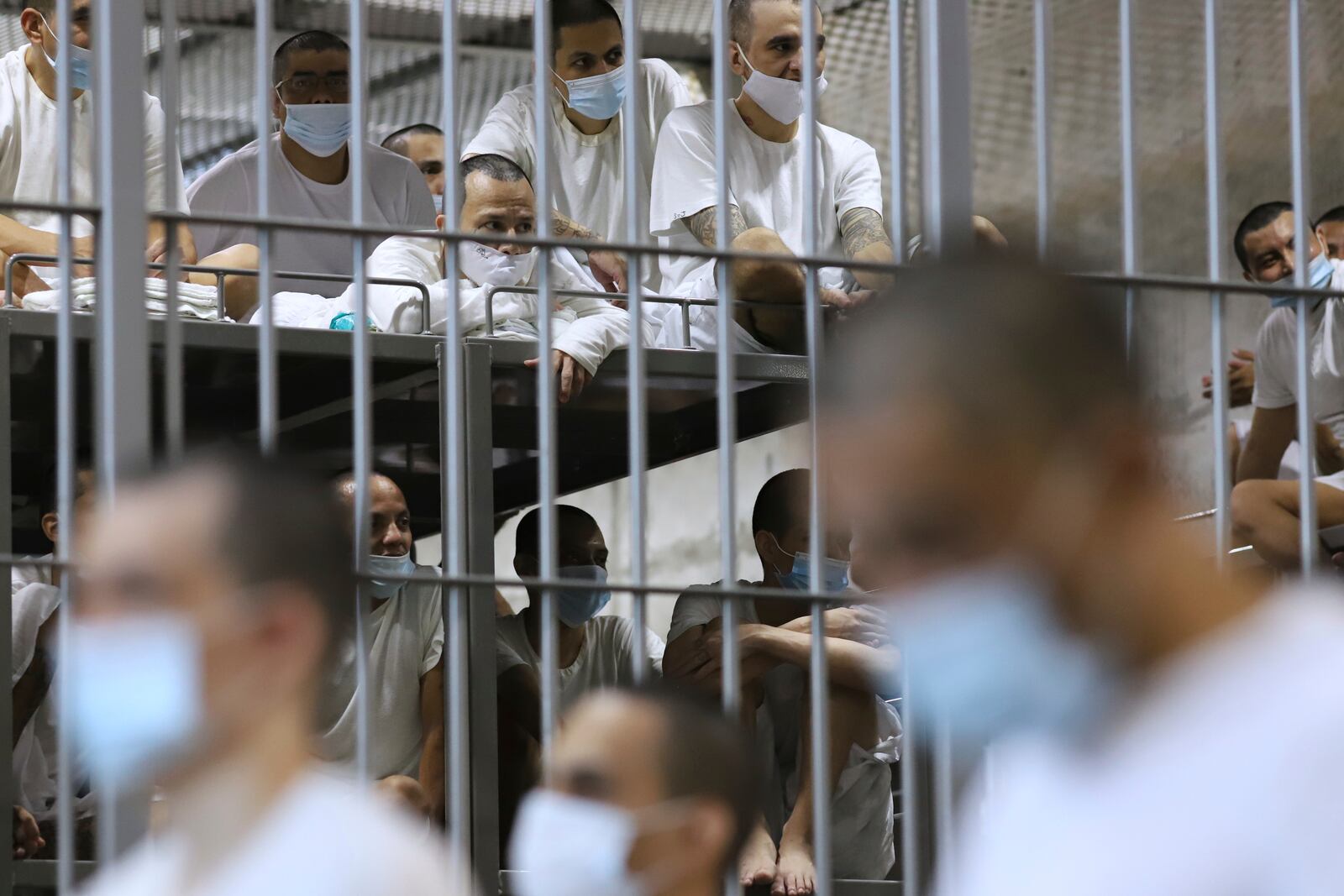 Prisoners sit in their cell as Costa Rica's Justice and Peace minister tours the Terrorist Confinement Center, in Tecoluca, El Salvador, Friday, April 4, 2025. (AP Photo/Salvador Melendez)