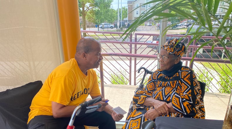 Ernist Muhammad, left, sits with Veda Renshaw, right, during a Juneteenth event at Gem City Market Saturday. Eileen McClory ./Staff