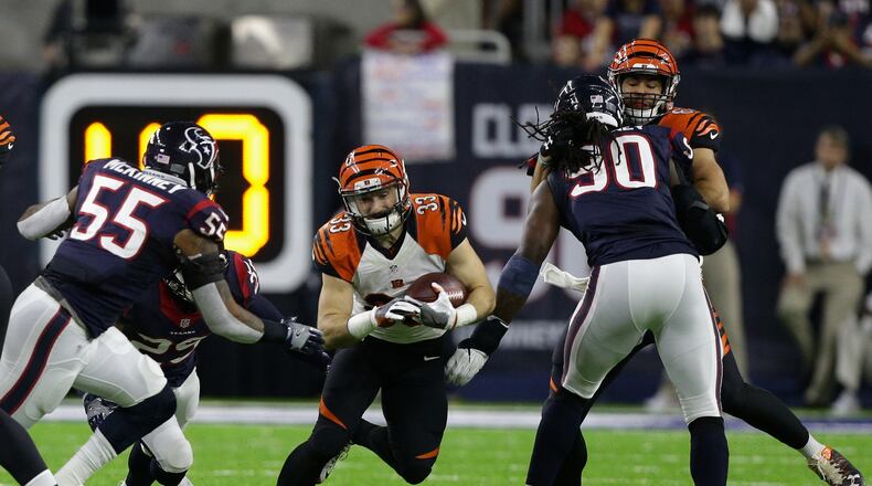 HOUSTON, TX - DECEMBER 24: Rex Burkhead #33 of the Cincinnati Bengals looks for room to run beyween Benardrick McKinney #55 of the Houston Texans abnd Jadeveon Clowney #90 at NRG Stadium on December 24, 2016 in Houston, Texas. (Photo by Bob Levey/Getty Images)