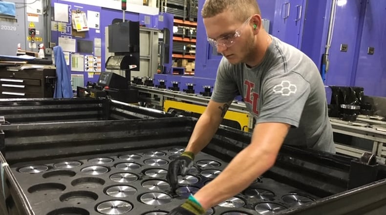 Michael Lensman arranges gears after cutting them on a Crown Equipment assembly line in New Bremen in 2019. THOMAS GNAU/STAFF